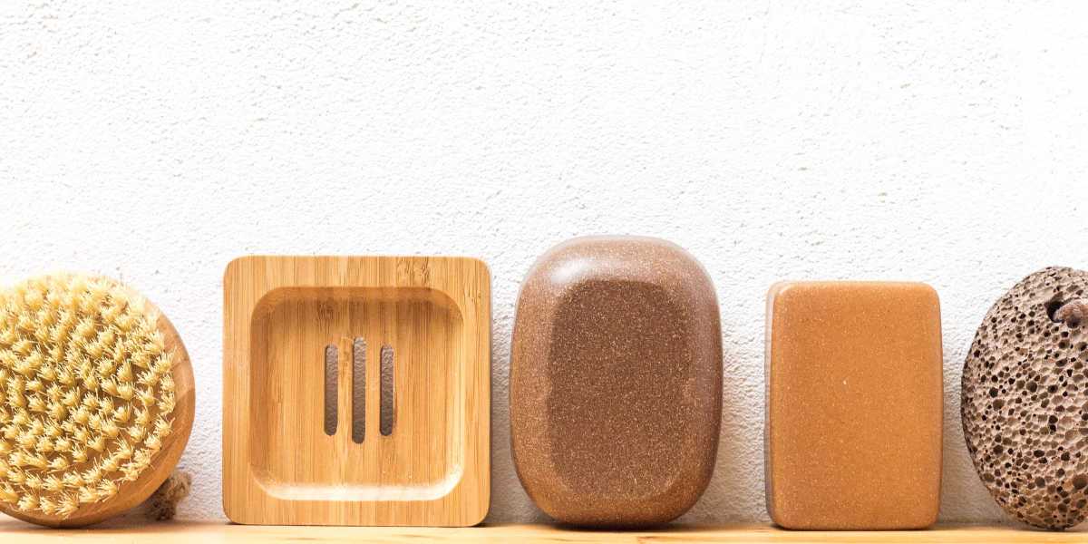 Massagebürste, Seifenablage, zwei Seifendosen und ein Bimsstein aufgereiht