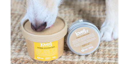 eine Dose WunderPflege und eine Dose aus Karton mit gelbem Etikett, das Pfotenpflegebad. Hundenase und eine Hundepfote im Bild.