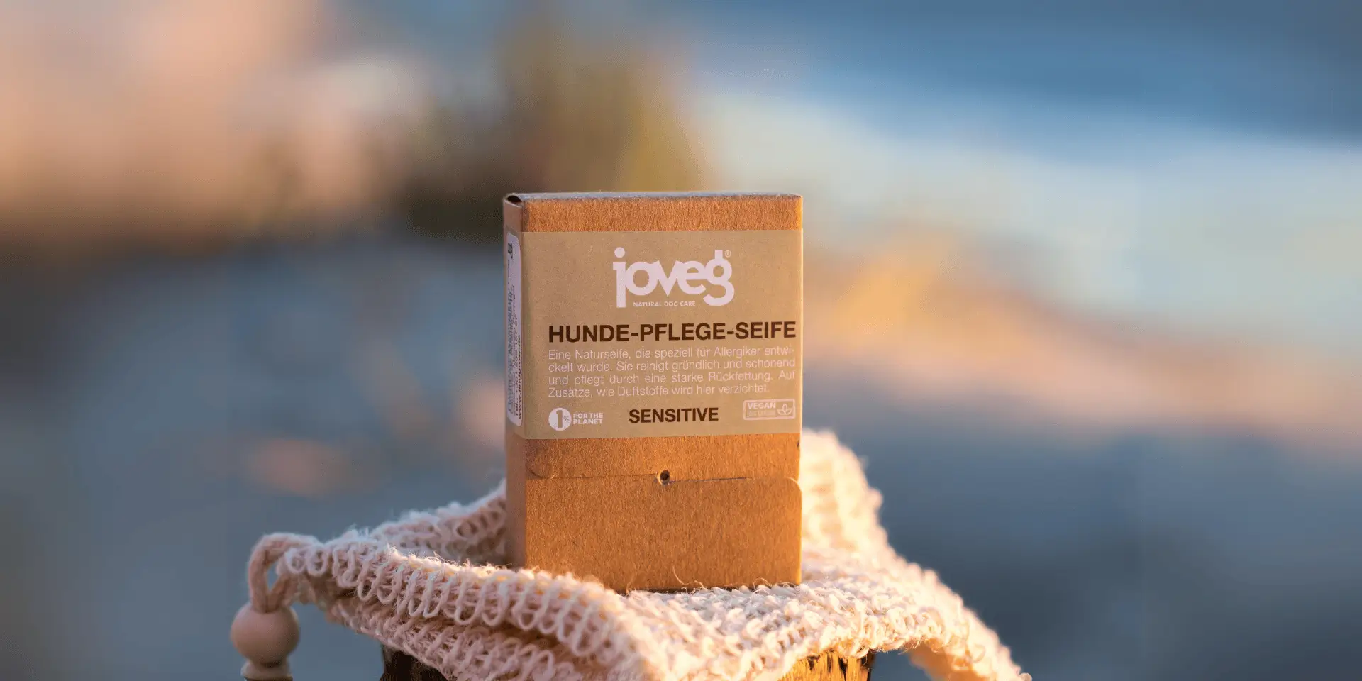 Eine Hundeseife Sensitive auf einem Seifenbeutel, Dünen und Meer im Hintergrund.