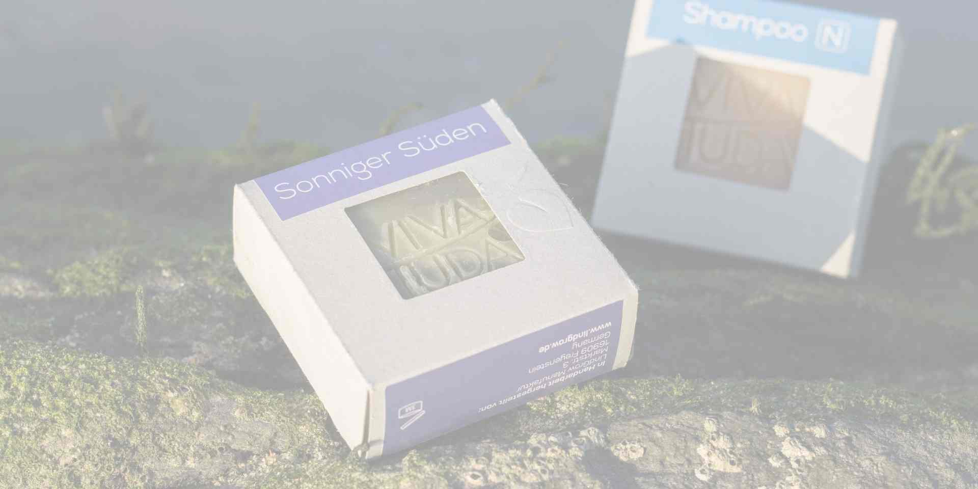 Zwei Seifen im Karton auf einem Stein in der Sonne